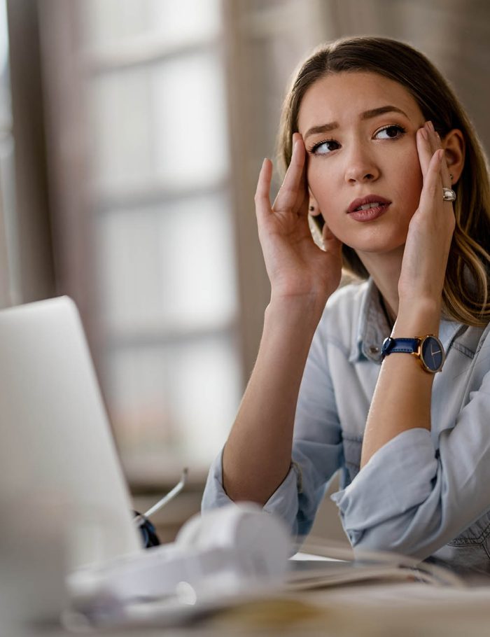 Mujer pensativa frente a la computadora